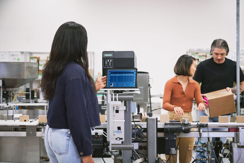 a man and a woman standing in front of a computer