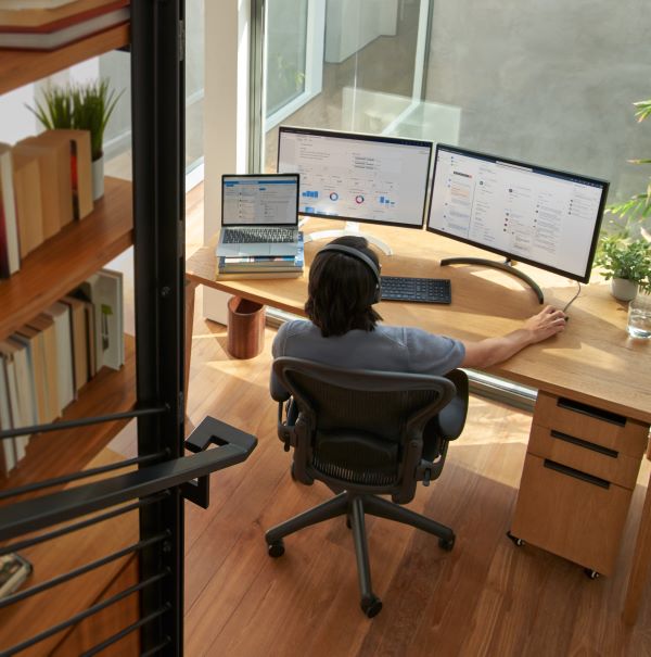 Man sitting at desk with 2 computer monitors